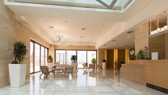 A well-lit, immaculately clean, white and natural wood hotel lobby.